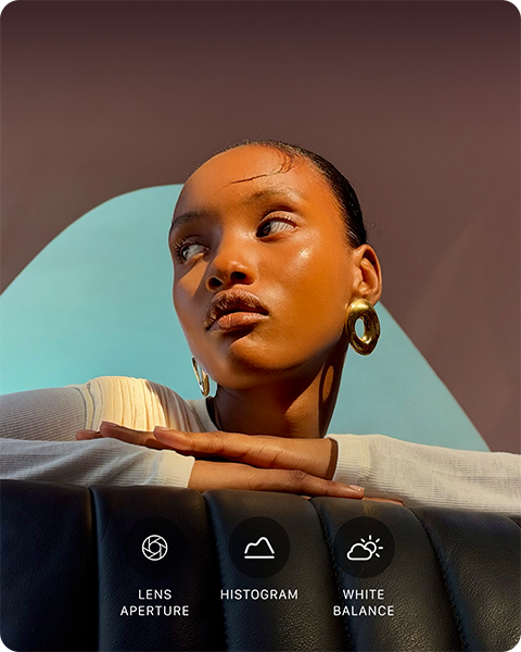 A person with their head turned to the side, bright light shines on them from opposite direction, their hands overlapped on a flat surface in front of them at shoulder height, three photo controls: Lens Aperture, Histogram, and White Balance