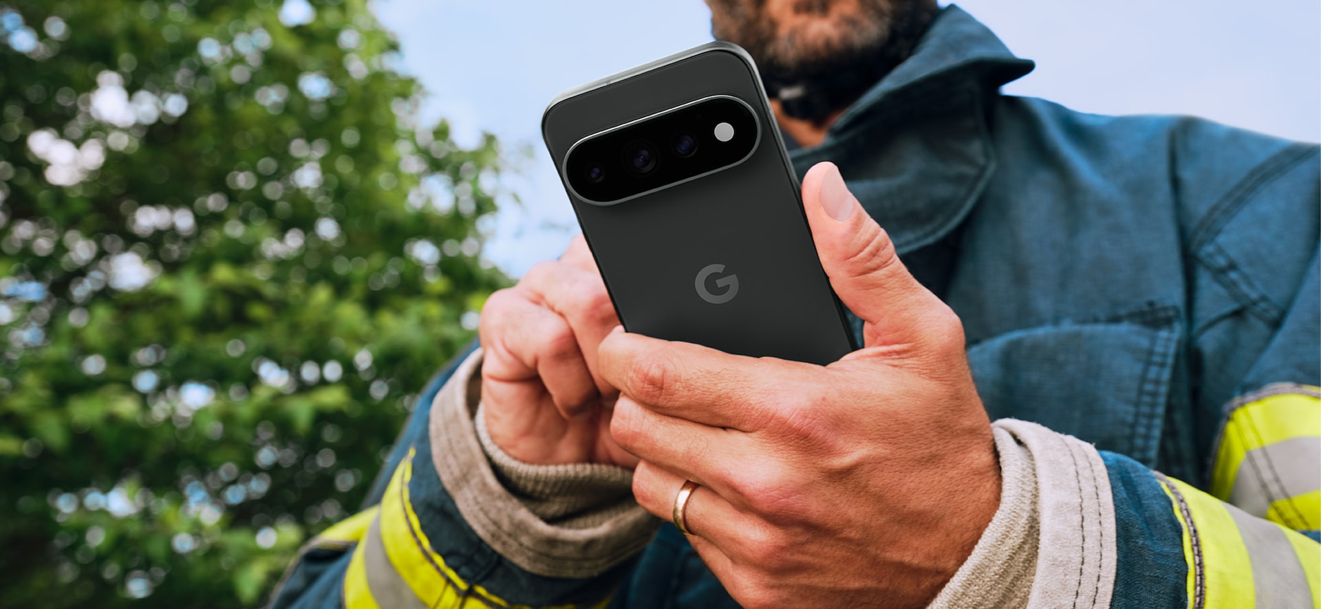 A man in heavy-duty work gear holding a Pixel 11 Pro.