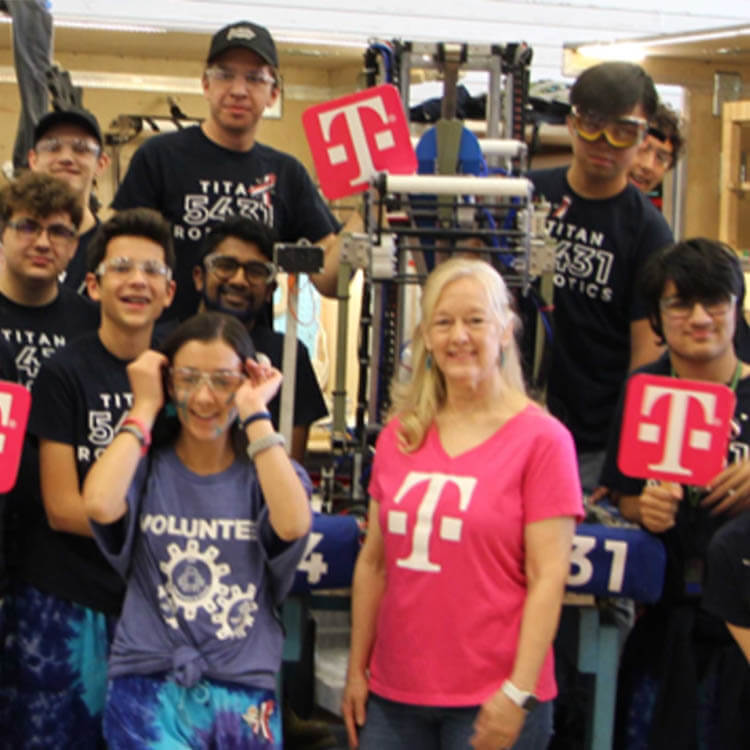 Empleada de T-Mobile con un grupo de adolescentes que trabajan en robótica