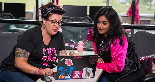 Two T-mobile employees looking into laptop