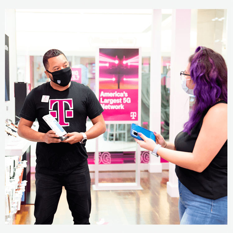 Hombre de T-Mobile hablando con un cliente acerca de celulares.