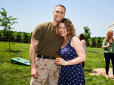 Man in military uniform hugging a woman and smiling