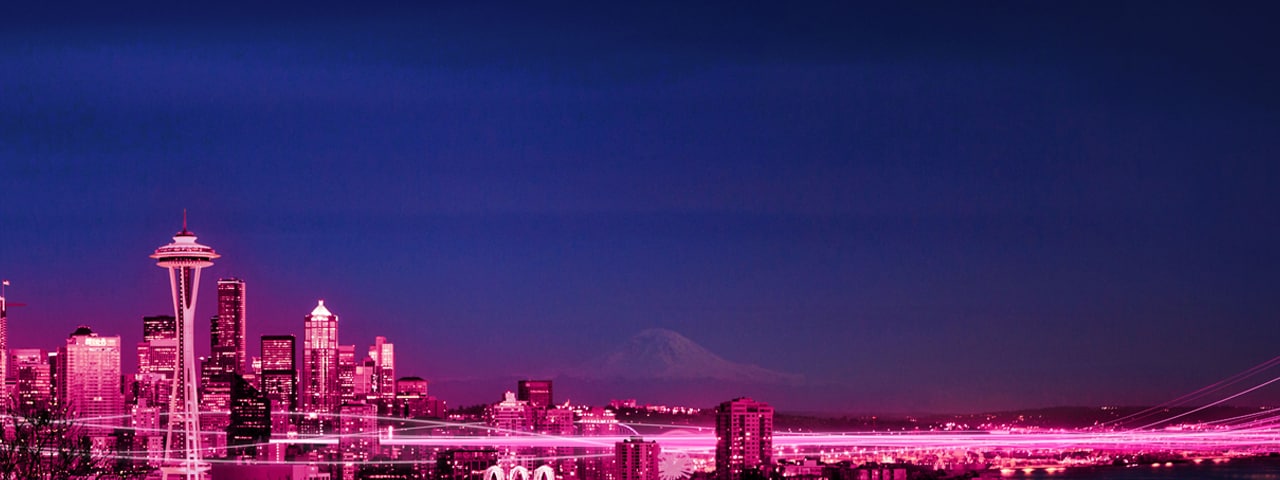 Downtown Seattle lit up in Magenta with Mt. Rainier in the background and bright Magenta beams flowing through the city.