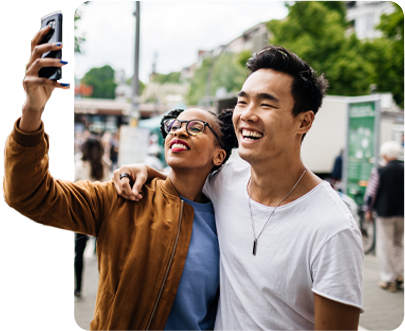 Two friends posing for a selfie in the middle of a public event.