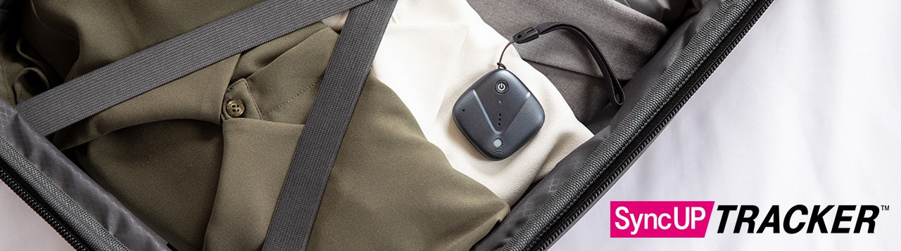 Sync-up tracker device resting on clothes packed in suitcase.