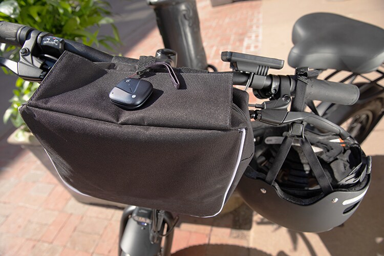 Sync-up tracker attached to black bag wrapped around bicycle handlebars.